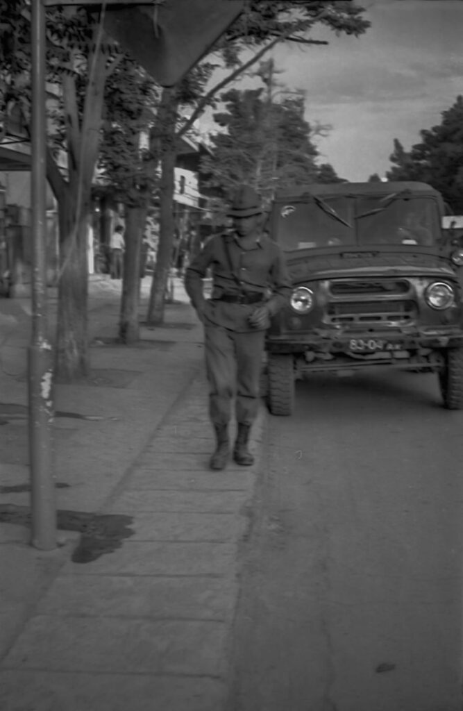 Soviet soldier next to a military jeep